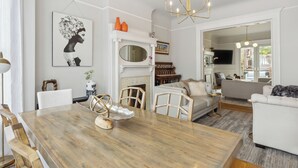 Un comedor con una mesa de madera, sillas y una lámpara de araña.