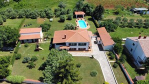 Propiedad residencial con piscina, varias edificaciones y jardín bien cuidado.