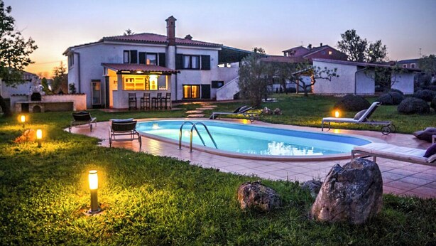 Una casa con piscina, mobiliario exterior y zona de bar.