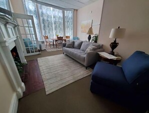 Relax in this stylish living room with a comfortable sofa, armchair, and dining area.