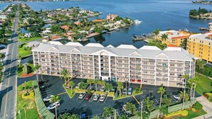 Hotel com vários andares, estacionamento, e vista para uma marina e para a água.