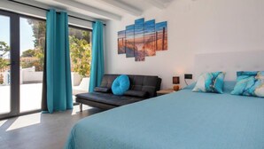 A modern bedroom with a large bed, a sofa, and a view through a sliding glass door. - Estrella Azul by Interhome (Calpe/Calp)