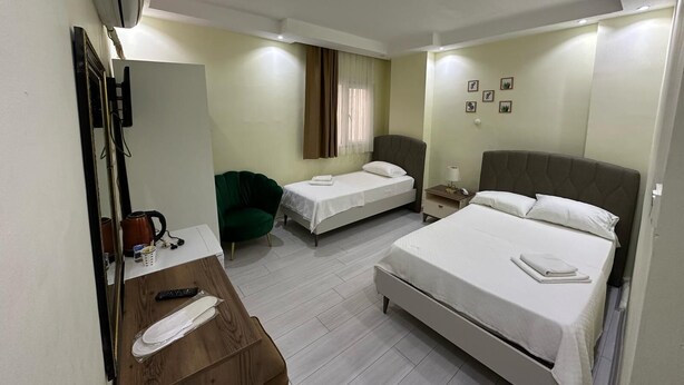 Habitación de hotel con cama, escritorio, teléfono, silla y espejo.
