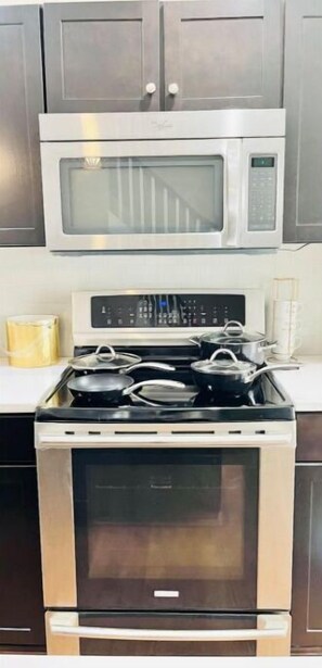 Kitchen features a gas stove with four burners and a stainless steel oven.