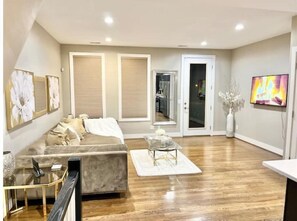 Relax in this stylish living room with a large sofa, flat-screen TV, and glass coffee table.