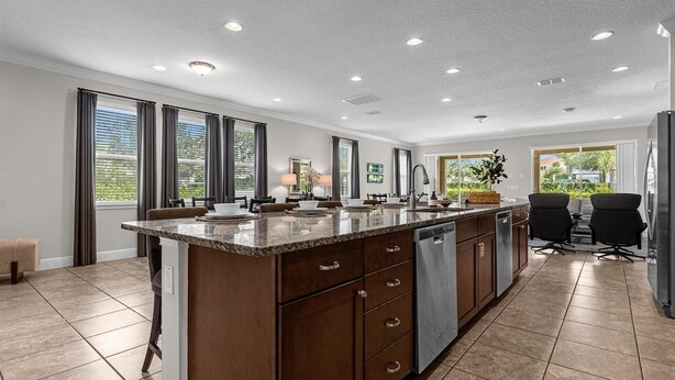 A modern kitchen with a granite countertop, wooden cabinets, and a built-in dishwasher.