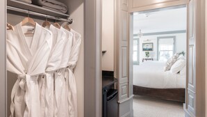 A hotel room with a neatly organized closet, a bed with white linens, and a view of the hallway. - The Davenport Inn (Portsmouth)