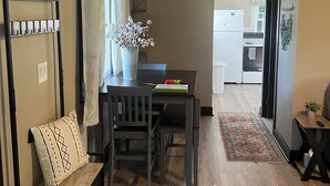 A compact living space with a dining area, kitchenette, and a wooden ceiling. - Looking for a getaway? This is the perfect cottage for you.  Pet friendly! (Schenectady)