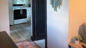 A hallway with a patterned rug, a black door, and a wall-mounted plant. - Looking for a getaway? This is the perfect cottage for you.  Pet friendly! (Schenectady)