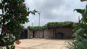 A paved courtyard with a brick wall, potted plants, and a grill area. - Luxury 1 Bedroom Ensuite house in Galilea Amanfro (Ngleshi Amanfro)