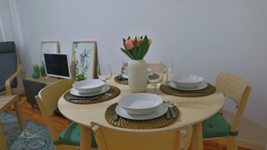 Een eettafel gedekt met borden, kommen en een vaas met bloemen.