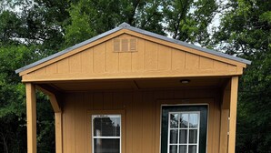 A small wooden structure with a green door, a window with blinds, a small porch with steps, and a flower pot on the porch. - Cozy little cabin in a small town  (Caney)