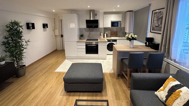 Un appartement moderne comprenant une cuisine, un coin repas et un salon.