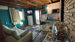 Un salon confortable avec un canapé, une table à manger et un coin cuisine équipé d’un réfrigérateur, d’un four à micro-ondes et d’une cuisinière.