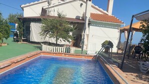 Une piscine rectangulaire à l’eau d’un bleu cristallin, entourée d’une terrasse carrelée.
