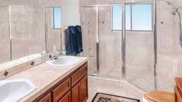 A modern bathroom with two sinks, a shower enclosure, and a toilet.