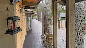 A wooden deck with a lantern, a signboard, and a potted plant. - Family Cabin in Graeagle CA w/King Bed & EV Charge (Graeagle)