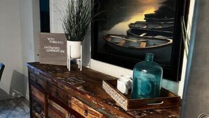 A wooden bar counter with a rustic design, a potted plant, a large framed artwork, and a sign indicating WiFi and password availability. - Big Stone Lake, SD-Bayview area Lake Cabin (Big Stone City)