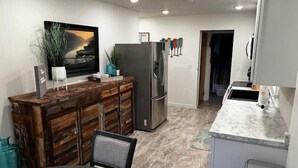 A modern kitchen with a wooden island, stainless steel appliances, and a marble countertop. - Big Stone Lake, SD-Bayview area Lake Cabin (Big Stone City)