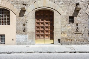 Un edificio de piedra con una puerta de madera grande, ventanas arqueadas y fachada de piedra.