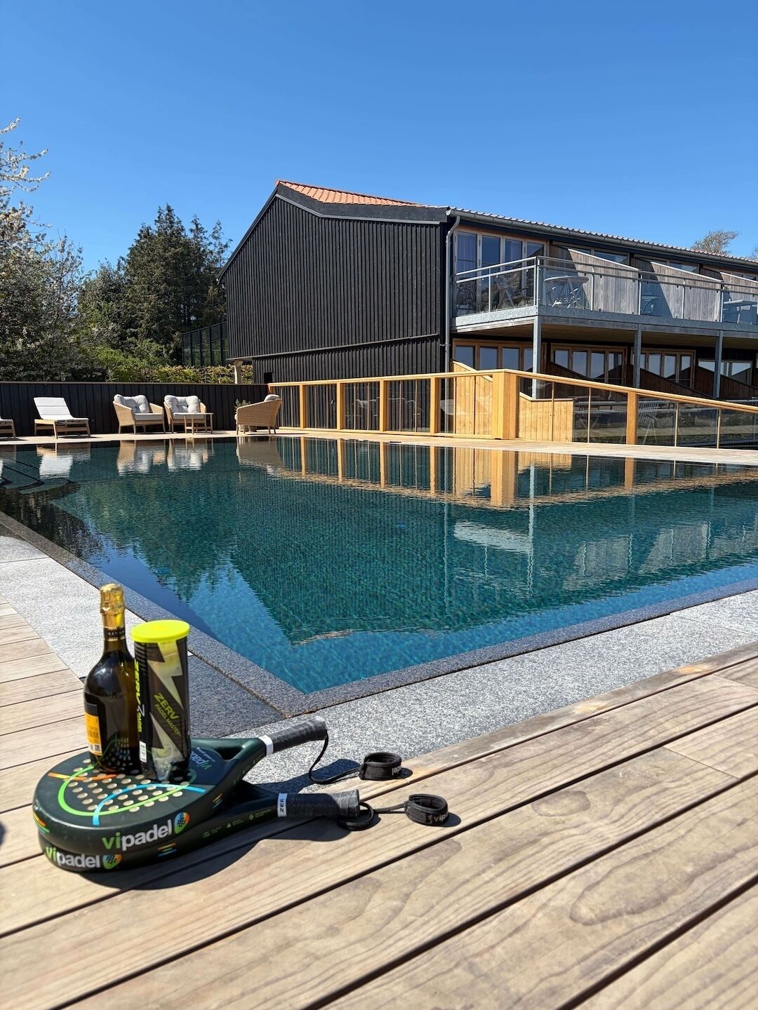 Una piscina al aire libre, tumbonas