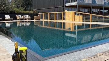 Una piscina al aire libre, tumbonas