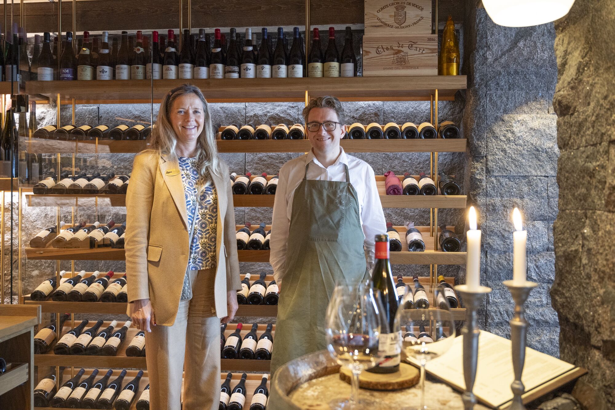 Una bodega con estantes y bodegas de madera que albergan numerosas botellas de vino.