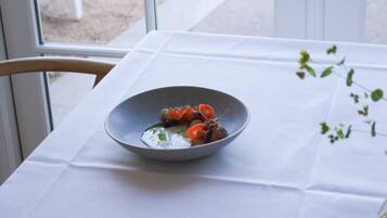 Une table avec un bol de nourriture, une chaise et une fenêtre.