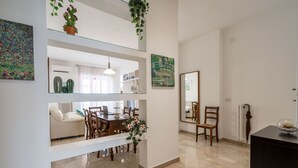 A dining area with a table, chairs, and a hanging plant.