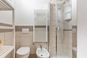 Een douche, een haardroger, een bidet, handdoeken