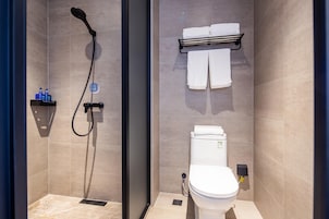 Un baño moderno con ducha de vidrio, inodoro y toallero.