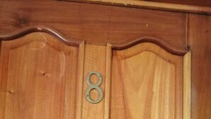 Eine Holztür mit einem Messing-Ziergriff mit der Zahl 8.