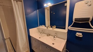Een bad, een haardroger, handdoeken, toiletpapier