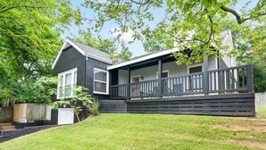 A two-story house with a covered porch and a garage. - Memories on Madison | Entire Home w/ Game Room & Outdoor Fire Pit (102 Madison Ter) (Clarksville)