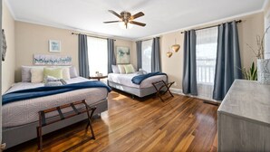 A bedroom with two beds, a ceiling fan, and a large window with curtains. - Memories on Madison | Entire Home w/ Game Room & Outdoor Fire Pit (102 Madison Ter) (Clarksville)