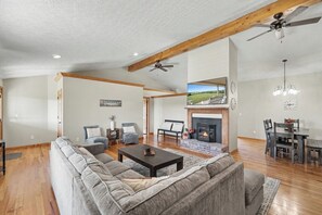 Una sala de estar amplia con chimenea, comedor y un gran ventanal con vistas panorámicas.