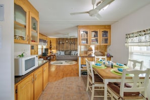 Kitchen and dining area with microwave, sink, and storage. Meals can be prepared and enjoyed at the wooden table for four.
