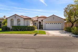 A residential house with a garage, a driveway, and a well-maintained lawn.