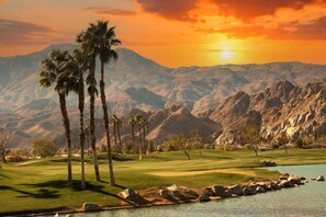 A golf course with palm trees, a lake, and mountains in the background. - Coachella Music Festival 10min walk to grounds (Indio)