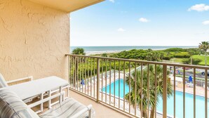A balcony with a view of a pool and beach. - Oceanfront Bliss | 4th Floor Condo w/ Heated Pool & Stunning Balcony Views! 🌊 (Cape Canaveral)