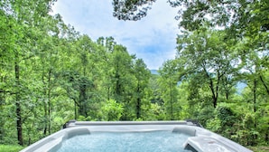 Un jacuzzi rodeado de frondosos árboles verdes.