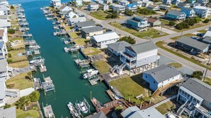 A marina with boats docked, surrounded by residential buildings with balconies and waterfront views. - Steps to the beach. Canal front with new dock. Clean, Cozy Getaway.   (Surf City)