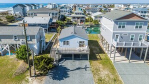 A coastal residential area with houses, a dock, and a clear view of the ocean. - Steps to the beach. Canal front with new dock. Clean, Cozy Getaway.   (Surf City)