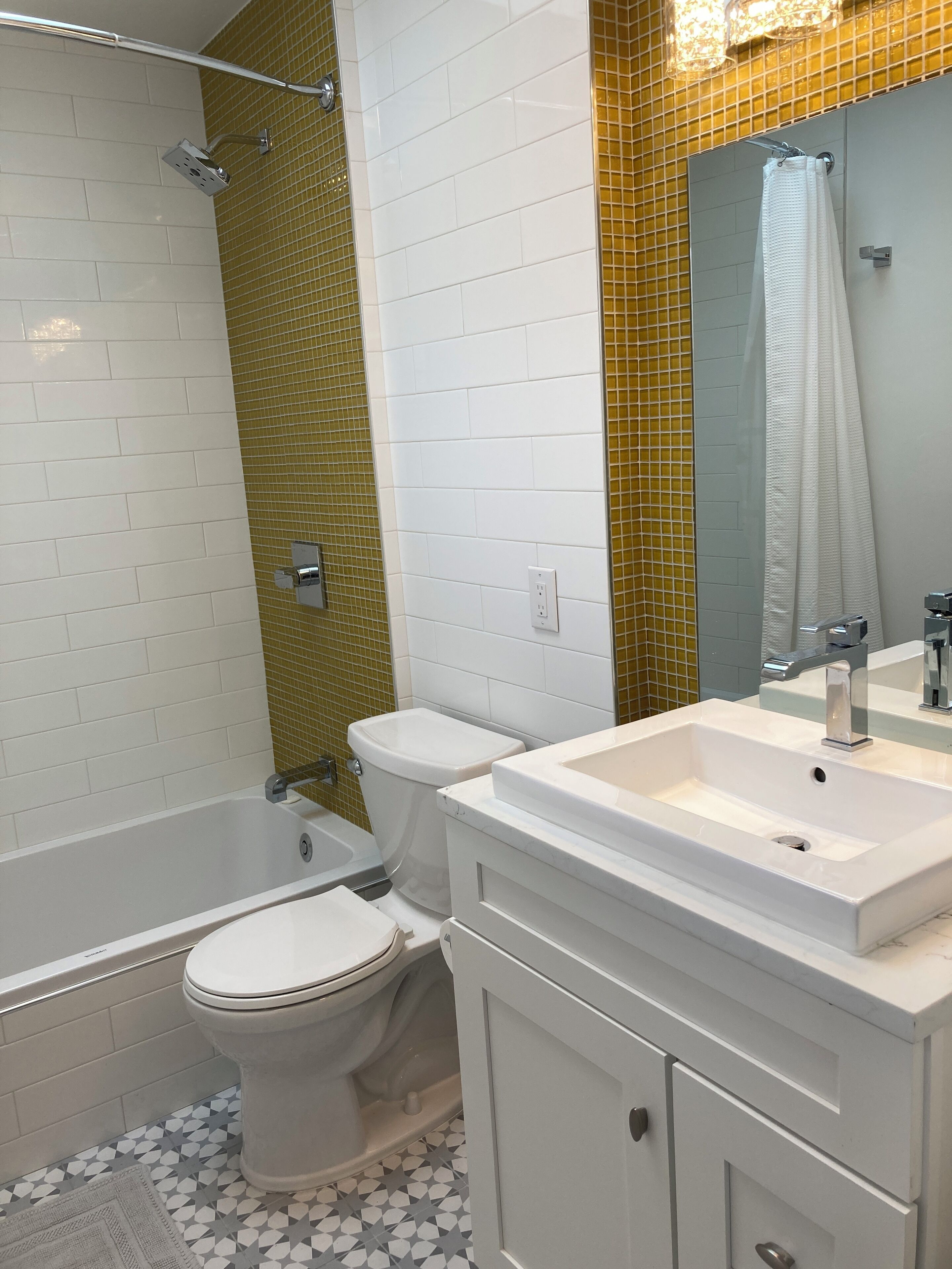 A modern bathroom with a bathtub, toilet, and vanity.