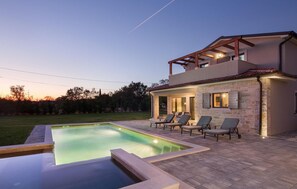 A modern house with a swimming pool, outdoor seating, and a stone facade. - Beautiful home in Marcana with sauna (Marcana)