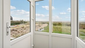 Ein Zimmer mit großem Fenster und Blick auf Strand und Autobahn.