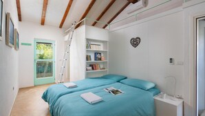 Une chambre avec deux lits, une échelle, une bibliothèque, une décoration en forme de cœur et une porte donnant sur une vue agréable.