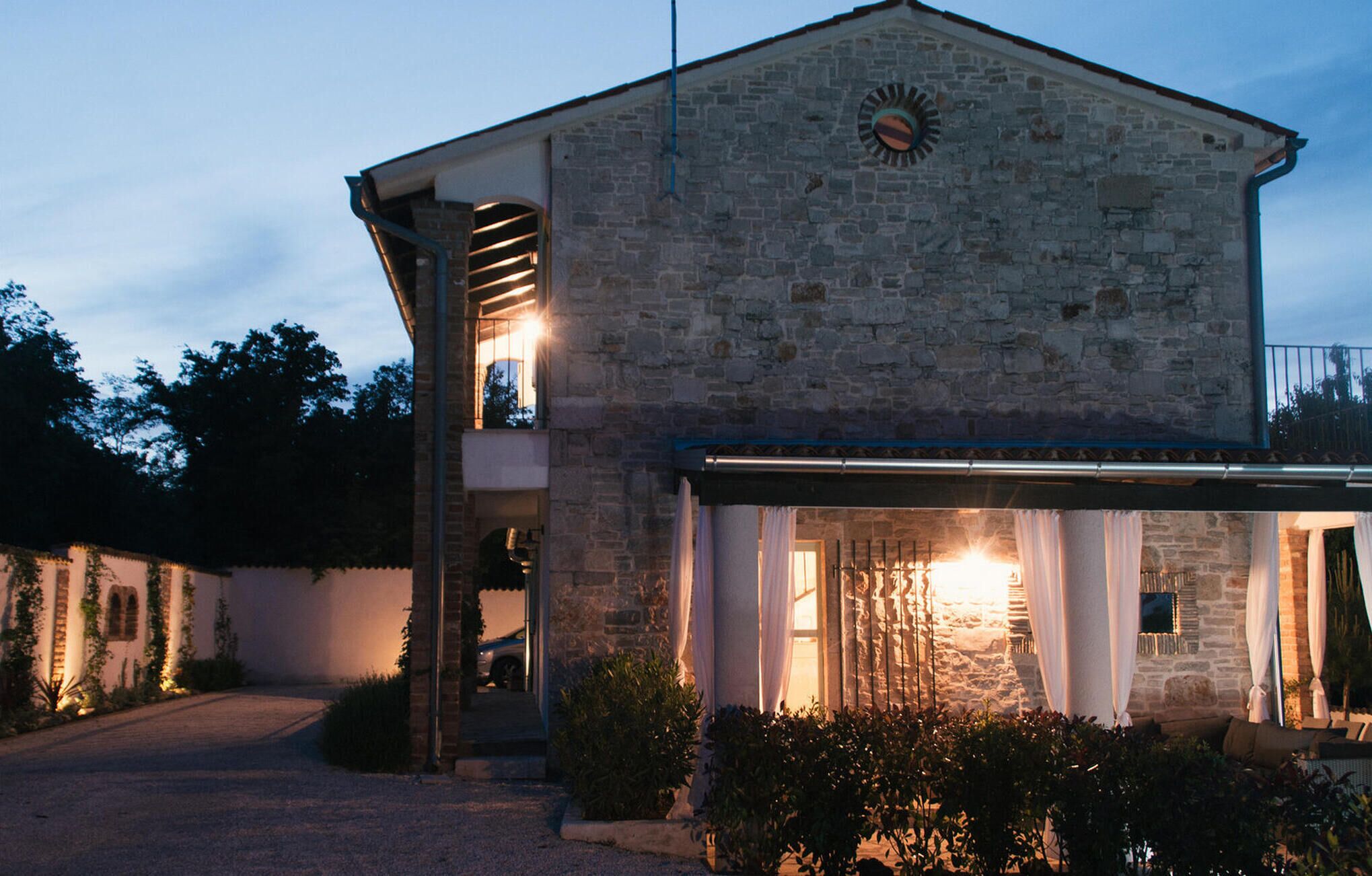 Un edificio in pietra con un balcone e un'area esterna coperta.