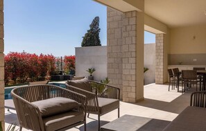 A patio area with a pool, outdoor seating, and a stone wall. - Amazing home in Vabriga (Vabriga)