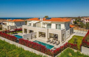 A modern two-story house with a swimming pool, outdoor seating, and a view of the sea. - Amazing home in Vabriga (Vabriga)